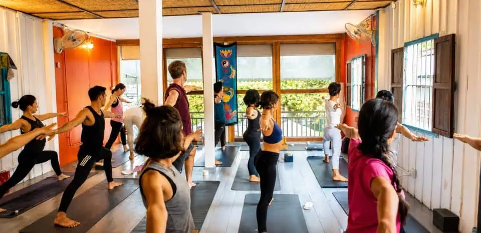 Group yoga class in Warrior II pose at the AZAHAR studio in Phnom Penh, Cambodia
