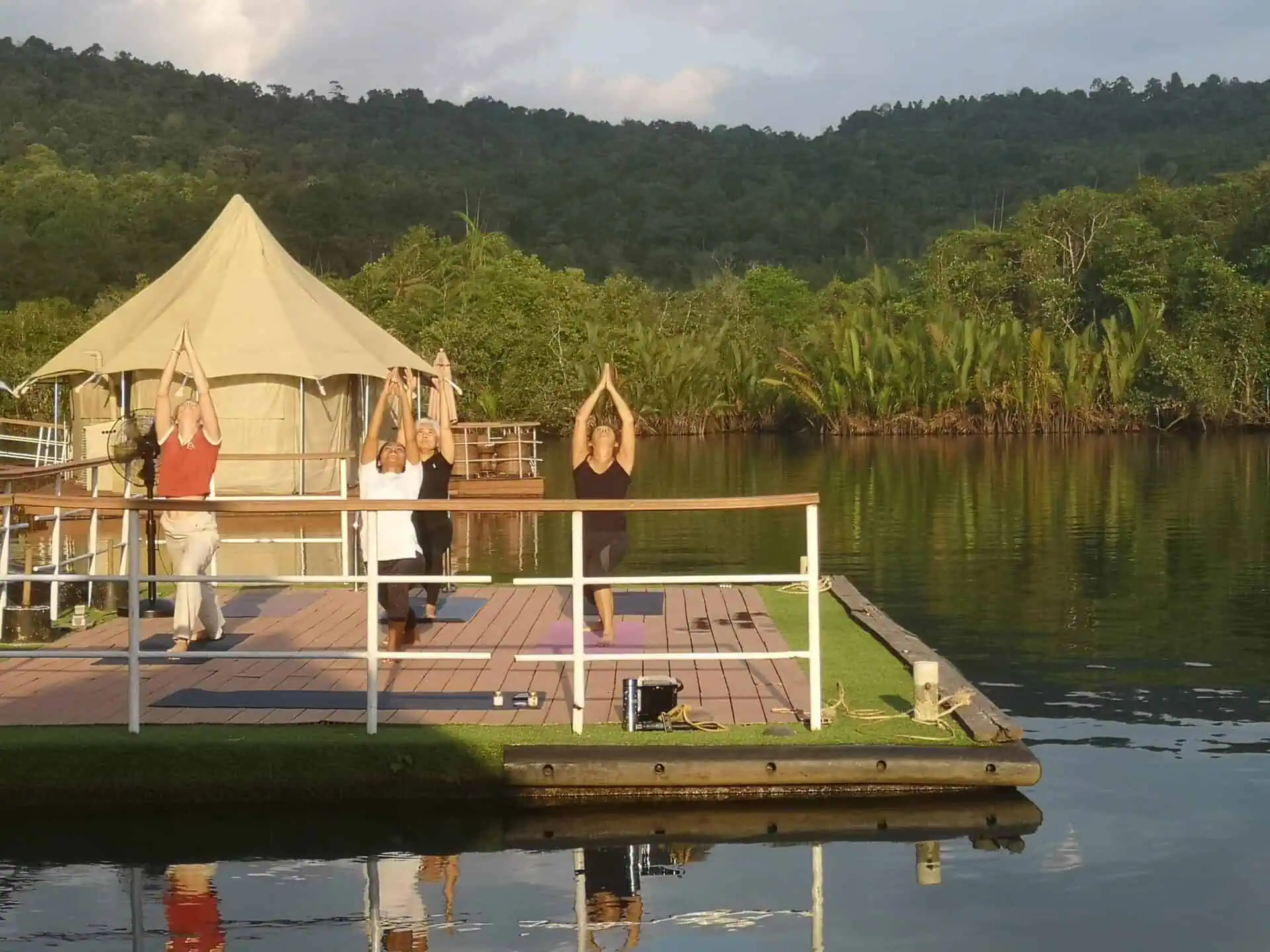 Morning yoga session on a floating platform overlooking the Tatai River at Canvas & Orchids Retreat
